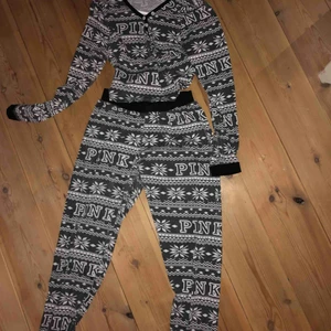  - Snyggt pyjamassätt från pink som inte är äkta. Det är ett par högmidjade pyjamasbyxor med en kroppad tröja med knappar som tillhör. 