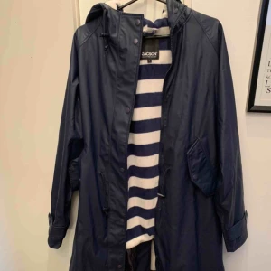  - Regnkappa, använd ett fåtal ggr. Matchade med hundens regnjacka som sedan blev för liten och nu är såld. Därav säljer jag denna! Fleecefodrad inuti, lång. Strl L i Marin.