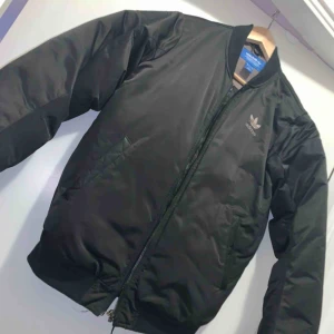  - Adidas bomberjacka, använd under en vinter. Har inga defekter förutom den lilla fläcken på ryggen sol jag tvättar bort innan den säljs!