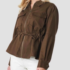  - Brun jacka från NA-KD, ”Short Oversized Marked Waist Jacket Brown”. Aldrig använd, säljer eftersom den är för stor för mig. Köparen betalar frakten.