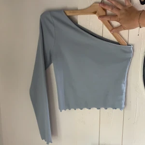 Gina tricot tröja - Super fin ljus blå tröja från Gina tricot, den är off shoulder på ena armen, aldrig andvänd 180kr och frakten är inräknad där💋💋💋