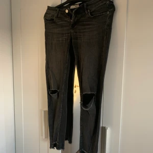 Svarta byxor med hål - Svarta fina byxor, hål på knäna och ”hål” nere vid ankeln. 