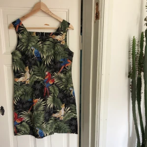 Unik sommarklänning - Vintage sommarklänning från Hawaii med djungelmotiv, papegojor, monstera och palmblad. Underbar ! En medium. 200kr 