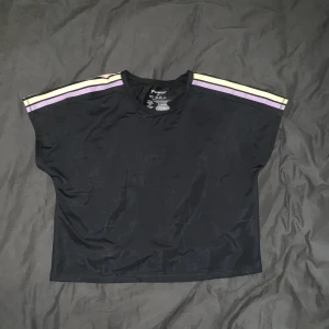 Croppad Träningstop srl. M  - Använd en gång men inte till träning. Croppad i modellen med pastell ränder på axlarna. 