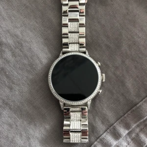 Fossil smartwatch  - Fossil smartwatch med stenar runt tavlan och på länken, 800:- eller bud, är öppen för förslag men inga skambud