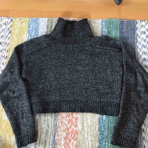  - En mysig cropped stickad svart polotröja från Zara. Polokragen kan du antingen ha hög eller vika ner beroende på smak. Tröjan är svartspräcklig i mjukt skönt material. Säljer på grund av storlek.