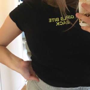 Svart snygg t-shirt från New Yoker. Väldigt bra skick. Texten är e neongrön och det står ”girls bite back”