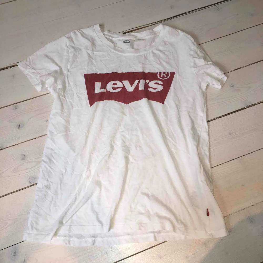 Klassisk vit Levis t-shirt med rött tryck. Storlek XS men passar snarare S, använt skick men inget fel på den alls. Nypris ca 500 kr. T-shirts.