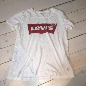  - Klassisk vit Levis t-shirt med rött tryck. Storlek XS men passar snarare S, använt skick men inget fel på den alls. Nypris ca 500 kr