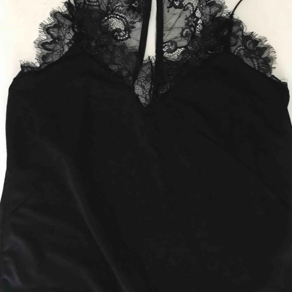 Ett svart linne med spets upptill och baktill i ”siden” material. 50kr + 30kr frakt. Toppar.