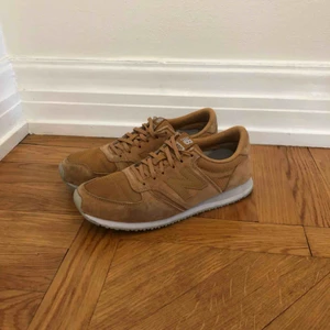  - New Balance beige/guld färg. 