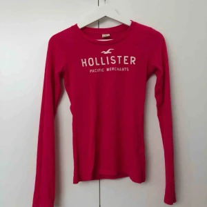  - Långärmad Hollistertröja i mörkrosa med vit text. I jättefint skick.