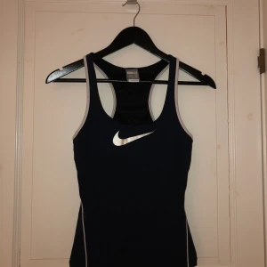 Träningslinne  - Träningslinne från Nike med inbyggd sport-bh. Inte så täckande fram och inte så mycket support för brösten. 