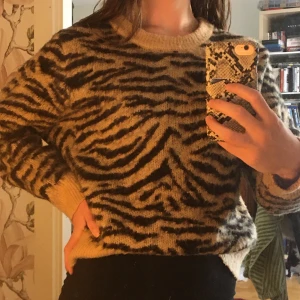 Stickad tröja tiger - Mysig och fluffig stickad tröja från H&m. Fint skick, nästan som ny. Nypris 400:- säljer pga inte min stil. Storlek medium men sitter bra på S.