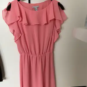 Superfin rosa klänning med volanger från H&M strl 36. I myclet fint skick. Kan fraktas om köparen betalar frakten. Hund finns i hemmet!