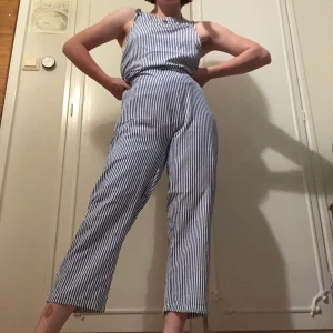 Randig jumpsuit - En blå/vit randig jumpsuit som är beställd i storlek XL men passar som en XS/S. Aldrig använd. Knytbara band.