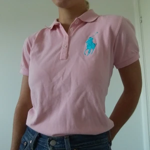 Pink Ralph Lauren Polo shirt - Säljer denna superfina rosa polo shirt! Sparsamt änvänd, nästan som ny, äkta Ralph Lauren. Kunden står för frakten.