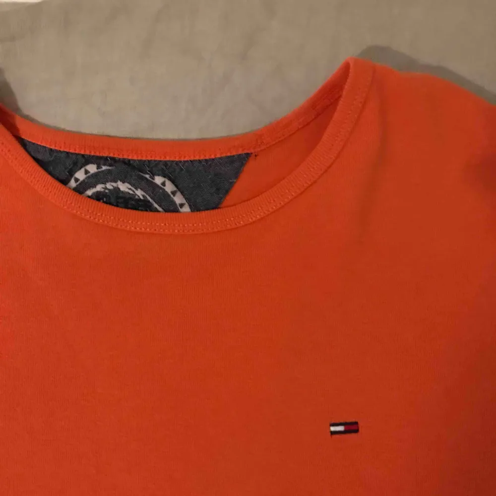 En orange t-shirt från tommy hilfiger, använd 1 gång. Frakt 40kr eller mötas upp inom stockholm. . T-shirts.