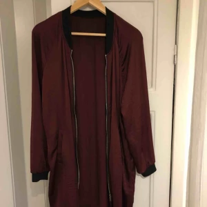  - Jättefin vinröd lång bomber jacka/kofta, som går till mitten av låren. Tunt och väldigt lent material!