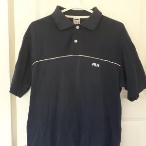 Fila Piké - En mörk blå vintage Fila Piké köpt på humana. Skicket är 4/5.  Funkar som oversized. 