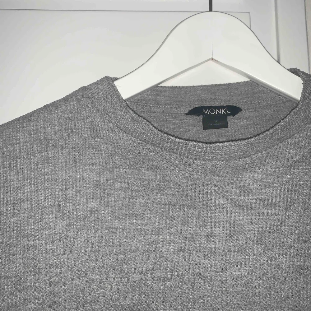 grå ribbad tröja från Monki, jätteskön o snygg! Lite kortare modell, säljer pga använder ej köpare står för frakt❤️. Tröjor & Koftor.
