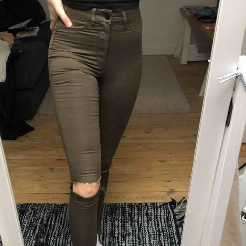 Högmidjade militärgröna skinnyjeans. Har hål vid knäna, och avklippta längst ner. Frakt ingår i priset🥰. Jeans & Byxor.