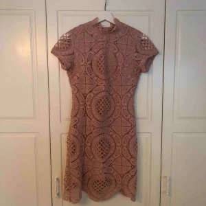  - Rosa klänning med spets på yttersta lagret. Använd vid 3 tillfällen, har dock hängt ett tag i garderoben. Storlek 36, s. Köpt på Nelly. 