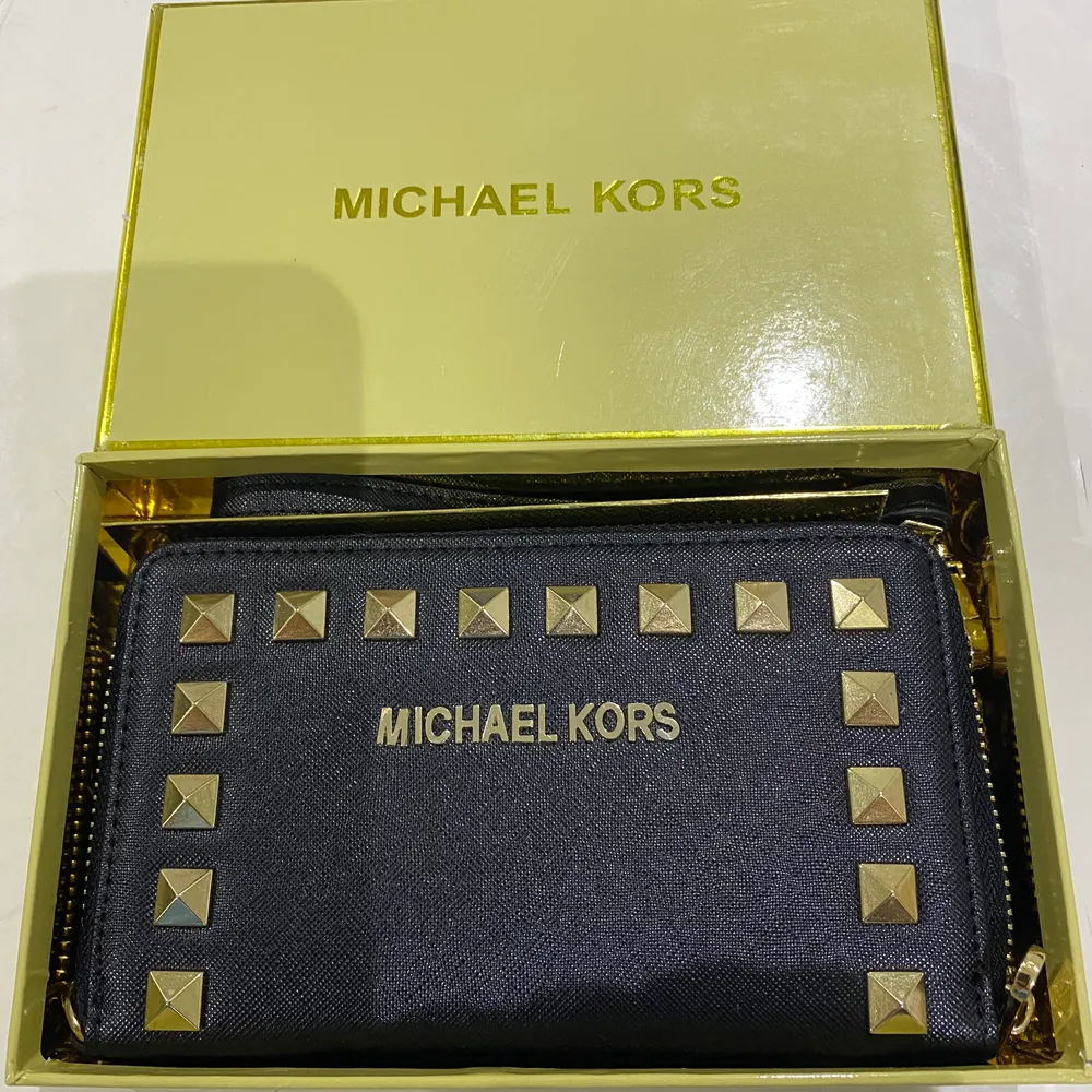 Helt ny Michael Kors plånbok med guldnitar på. Säljer den för att jag redan har en plånbok jag trivs med. . Väskor.