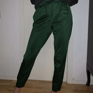 Byxor  - Fancy mjukisbyxor här!! Dem är mörkgröna och glansiga. På bilden ser ni mig som är 182 cm lång, därför ser byxorna korta ut, men det är dem alltså inte!