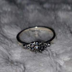 En silvrig ring med fina mörka stenar som detaljer. Fått den av en släkting men jag använder tyvärr inte ringar så vill att den ska få ett annat hem. Köpare står för frakten