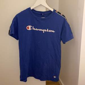 Blå t-shirt ifrån Champion i storlek Small. Fint skick men ganska använd.