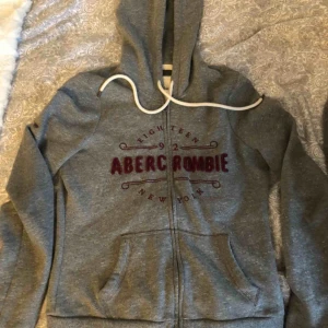  - Supermysig grå kofta med rött tryck på framsidan😍 Väldigt bra skick! Alla plagg tvättas innan de fraktas och köparen står för frakten💕