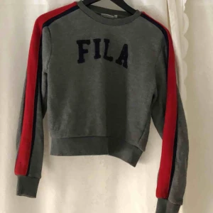  - Jättefin fila tjocktröja som är grå med röda sträck på armarna. Jättefint skick använd ett fåtal gånger. 