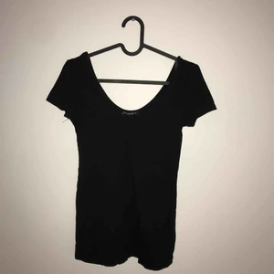  - Svart t-shirt med vid urringning. Supersnygg med halsband eller choker till :)  Frakt tillkommer