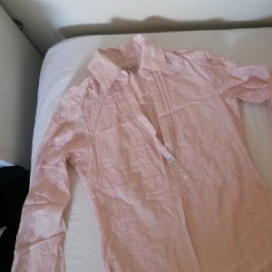  - En något skrynklig blus/tunika i söt ljusrosa. Fint skick