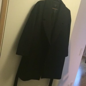  - Fin kappa med bälte från märket COS.
Svart 100% Ull med 100% viskos foder.
Använt fåtal gånger så i väldigt bra skick.
Frakt tillkommer. 