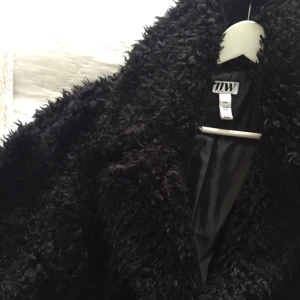  - Superfin kappa i luddigt material, fint skick och använd högst fem gånger. Storleken är XXS men passar någon upp till M. Går ungefär till knäna på någon som är 165 cm