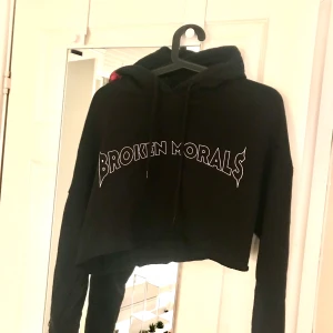 Svart hoodie med broderade 🥀  - Jättesnygg hoodie med texten ”broken morals” på framsidan och broderade rosor på luvan!! Sparsamt använd och jag har croppat den själv ♥️ Frakt tillkommer, skicka meddelande för mer info!