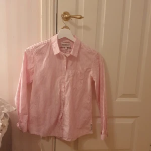 Rosa randig skjorta - Rosa randig skjorta från KappAhl. Ficka på vänstra bröstet. Använd fåtal tillfällen så i fint skick. Hör av dig vid intresse🥰🥰
