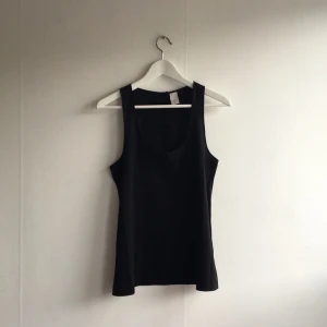  - Snygg svart topp med knappar i ryggen
