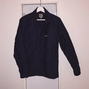  - Svart Carhartt Jacka strl Medium. Fyra fickor. Riktigt bra kvalité och tjockt tyg. 
Använd ett fåtal gånger.
Skick 8.5/10.
Köpare betalar frakt!