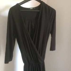  - Byxdress strl S. Svart i bomull, djup urringning/omlott och långa ben. 