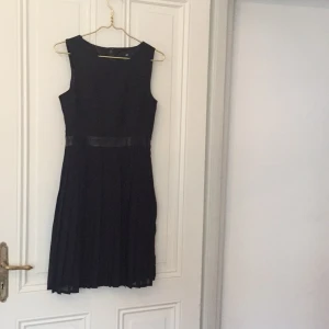  - Svart, klänning med klockad kjol/nederdel från H&M, öppen i ryggen. Använd en gång så i toppskick. Storlek 38. 