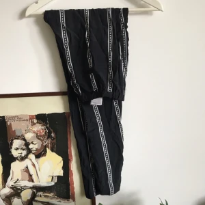  - Snygga byxor med ränder. Två fickor bak och markerad rand på sidorna av benen. I lite tunnare material men inte transparenta. 