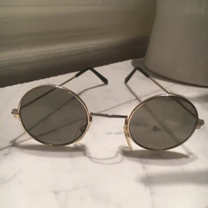  - Små runda solglasögon med svart toning.