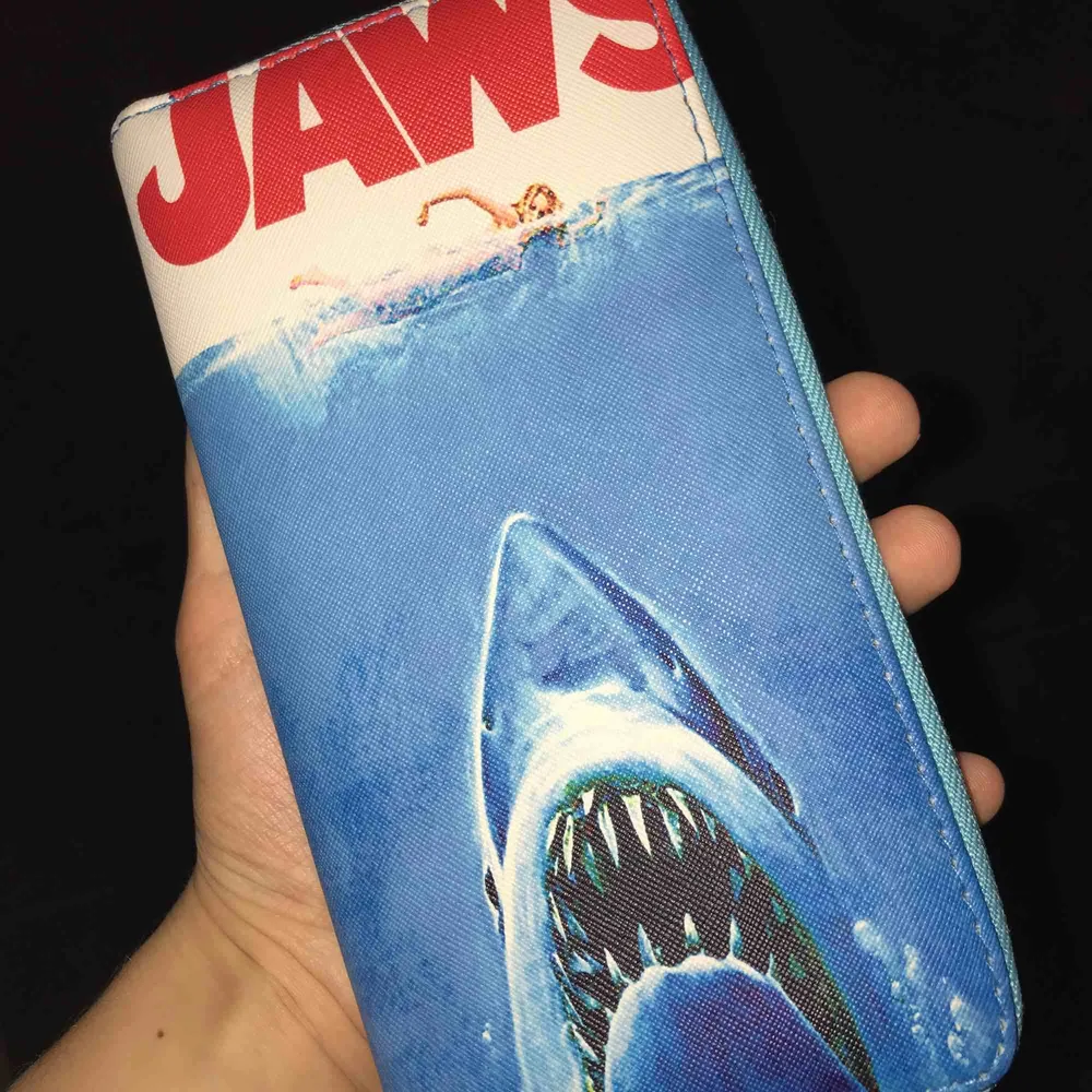 Plånbok med tryck från filmen JAWS matchar till mycket då den har ganska stilrena färger💙❤️🤍🧡. Accessoarer.