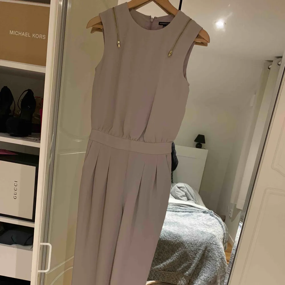 Beige Jumpsuit från wearhouse, storlek 34 men passar en 36a också! Dragkedja i ryggen samt fram på axlarna som detalj! Använd 1 gång så i nyskick! . Kostymer.