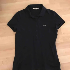  - Lacoste piké i mörkblått