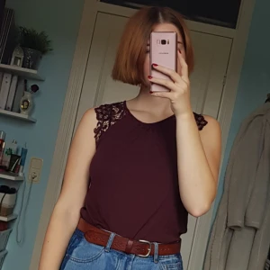  - Löst sittande plommonfärgat linne med breda axlar i spets