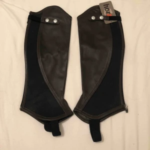  - Chaps i mörkbrunt läder, oanvända, är inte säker på storlek men tror dom är L, kan mäta om du vill veta. Stretch och dragkedja bak.